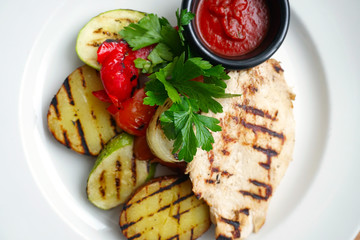 grilled chicken and vegetables on a white plate