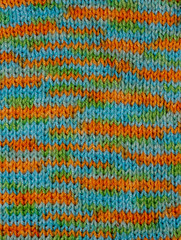 Knitted woolen colored background. Texture of multi-colored wool close-up. Knitted fabric, handmade, knitting. Yellow, green and blue scarf pattern
