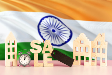 India real estate sale concept. Wooden house model with discount tag on national flag background. Copy space for text.