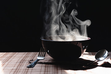Steam and smoke Instant noodles in bowl on wooden table and nature light and black background,...