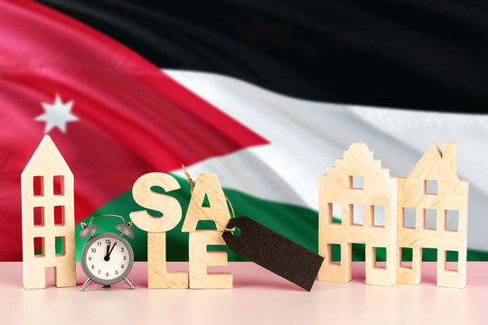 Jordan real estate sale concept. Wooden house model with discount tag on national flag background. Copy space for text.