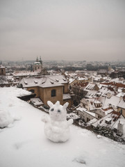 snowman with view of old town prague in winter