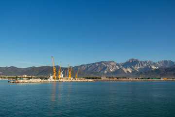 Fototapeta premium Italy, Tuscany: view of the port in Marina di Carrara and in the background the Apuan Alps with the marble quarries
