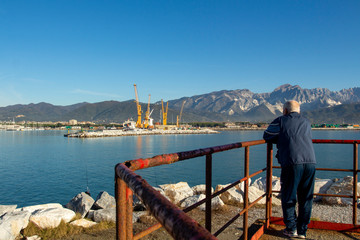 Fototapeta premium Italy, Tuscany: view of the port in Marina di Carrara and in the background the Apuan Alps with the marble quarries