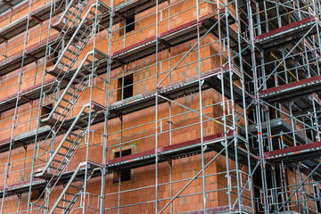 Scaffolding on a construction site, construction site and nice weather, no workers, blue sky, sunny day, scaffolding stairs