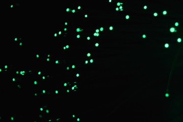 New Year and Christmas color illumination. The illusion of a salute explosion. The quirks of light fiber optic lamp. Blurry circles, bokeh on a dark background. Big explosion.