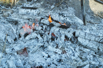 Ashes with some flames stayed after burning fire for preparing barbecue in hot summer day