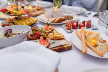 table setting with meat, salmon, lot of fruit and vegetables, cheese, wallnuts and honey