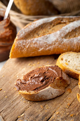 Fresh Homemade Sliced French Baguette Bread topped with chocolate On Wooden Bread Board