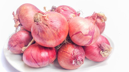 Big bulb purple onions on white plate and background. Farming, harvest and ingredients.