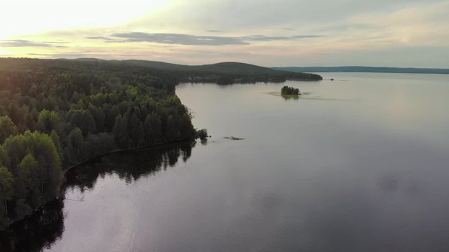 Night Northern seascape on lake Onega-waves beat on the forest shore, the water reflects the sky. The beauty of Karelian nature. Aerial view