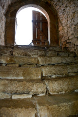 Old stone steps in a castle, looking up to an open door