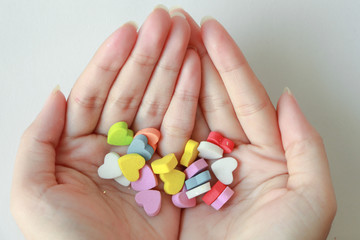 tiny colorful heart on woman hand. Love valentine concept.