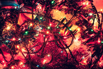 mixed together Christmas decorations, and on top of a garland with sparkling lights