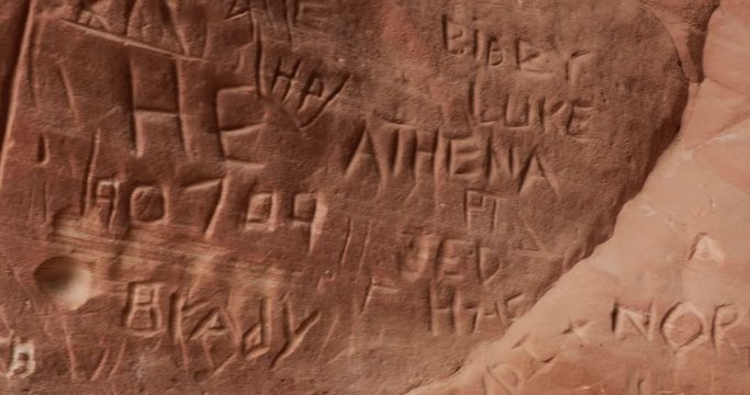 random names etched into sandstone, carved graffiti