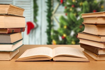 Stack open old books on wooden desk