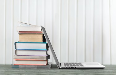 Stack of books with a laptop on the table