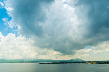 Fototapeta na wymiar heavy black cloud over the beautiful lake Sevan in Armenia, picturesque summer landscape