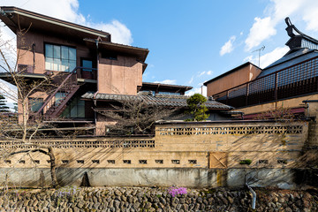 Fototapeta premium Takayama, Japan Hida Enako river in Gifu prefecture in Japan in spring in traditional village with wide angle view of flowers on embankment