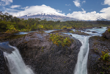 Landscape of the Osorno volcano with the Petrohue waterfalls and river in the foreground in the lake district near Puerto Varas and Puerto Montt, Chile.