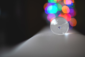 A Christmas tree in a lensball with bokeh reflection.