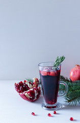 Pomegranate Christmas cocktail with champagne, soda and rosemary on a white table. Xmas drink.