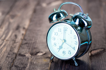 7 hours retro steel alarm clock on wooden boards