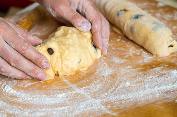 Female hands prepare yeast dough with raisins for pies