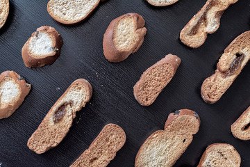 Wheat rusks on a wooden dark background.
