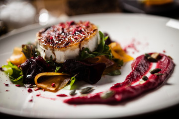Grilled goat cheese salad served on a plate in restaurant