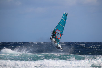 Windsurfer jumping a front loop in the turquoise waves of the Atlantic ocean (El Medano, Spain)