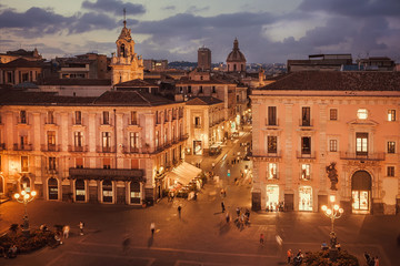 Obraz premium Streets of night city with some people walking around shops, palaces, local cafes, Catania. Sicily.
