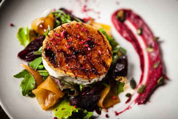 Grilled goat cheese salad served on a plate in restaurant