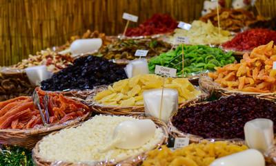 farmers market for spices, aromatic herbs and dried fruits in Italy. the names of herbs and spices in Italian and the price in euros are written on black plates
