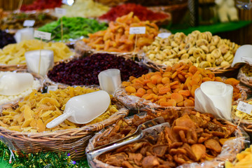 farmers market for spices, aromatic herbs and dried fruits in Italy. the names of herbs and spices in Italian and the price in euros are written on black plates