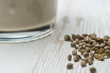 Hemp milk is poured into a glass. Nearby marijuana seeds. close-up.