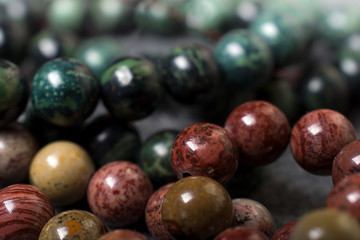 Natural green, brown and yellow stone beads, made of geological minerals ,closeup.