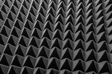 Abstract background in the form of pyramids and dragon scales. Acoustic black foam rubber.