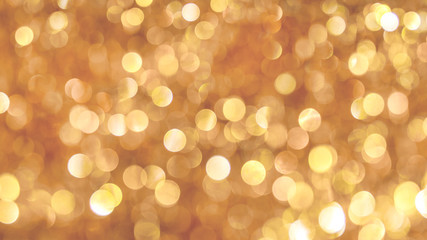 Obraz premium Bright light bokeh on golden background, festive Christmas background_