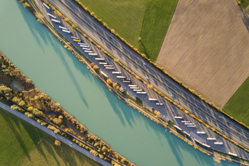 Top down aerial view of highway interstate road with fast moving traffic and parking lot with...