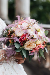 Bride, flowers. Bouquet of flowers. Bridal bouquet. Florists. Wedding bouquet from different colors,, the bride is holding a bouquet in her hands