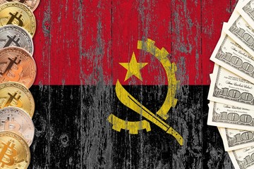Angola savings concept. Bitcoins and dollar banknotes on the side of national flag with wooden background. Trading currencies.