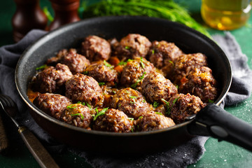 Fried meatballs with sauce on pan