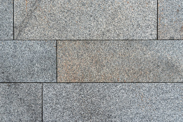 Texture of gray horizontal road granite tiles. Stone background. Modern paving slabs. Motley pattern.