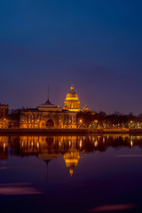 Fototapeta na wymiar Admiralty embankment with its historical buildings and the Neva river with reflections