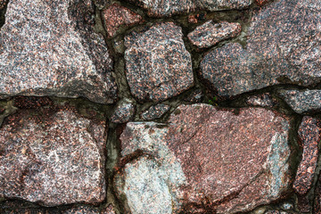 old stone wall of uneven granite stones
