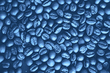 Background of classic blue color coffee beans. Monochrome coffee beans texture. Coffee beans classic blue background. Trendy color 2020. Out focus.