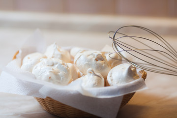 Little sweet meringue in a basket in kitchen
