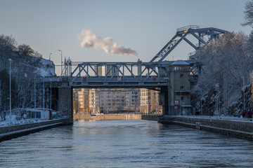 Bridge in th shadow at a port with houses on a pier a sunny and snowy winter day in Stockholm