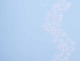 composition of white snowflakes on blue background, flatlay